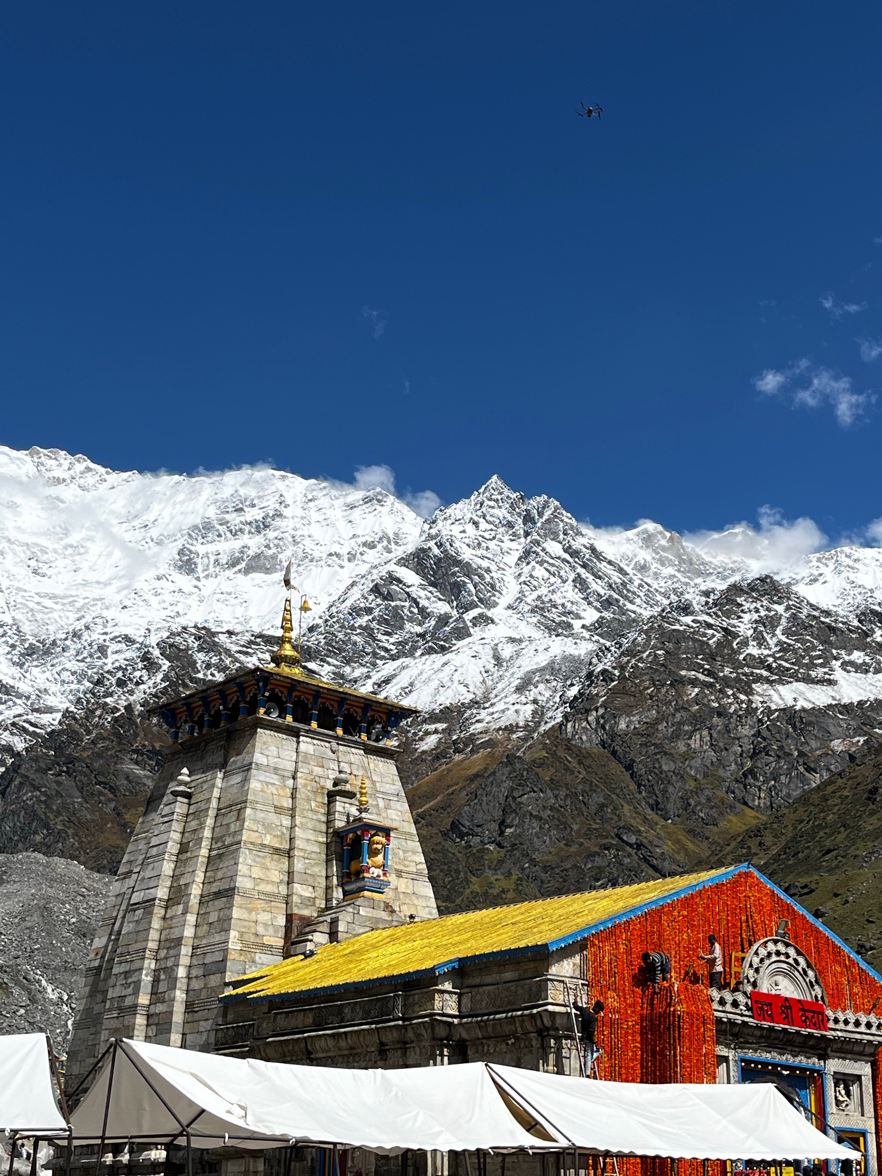 A stone Himalayan temple below a wall of snow peaks