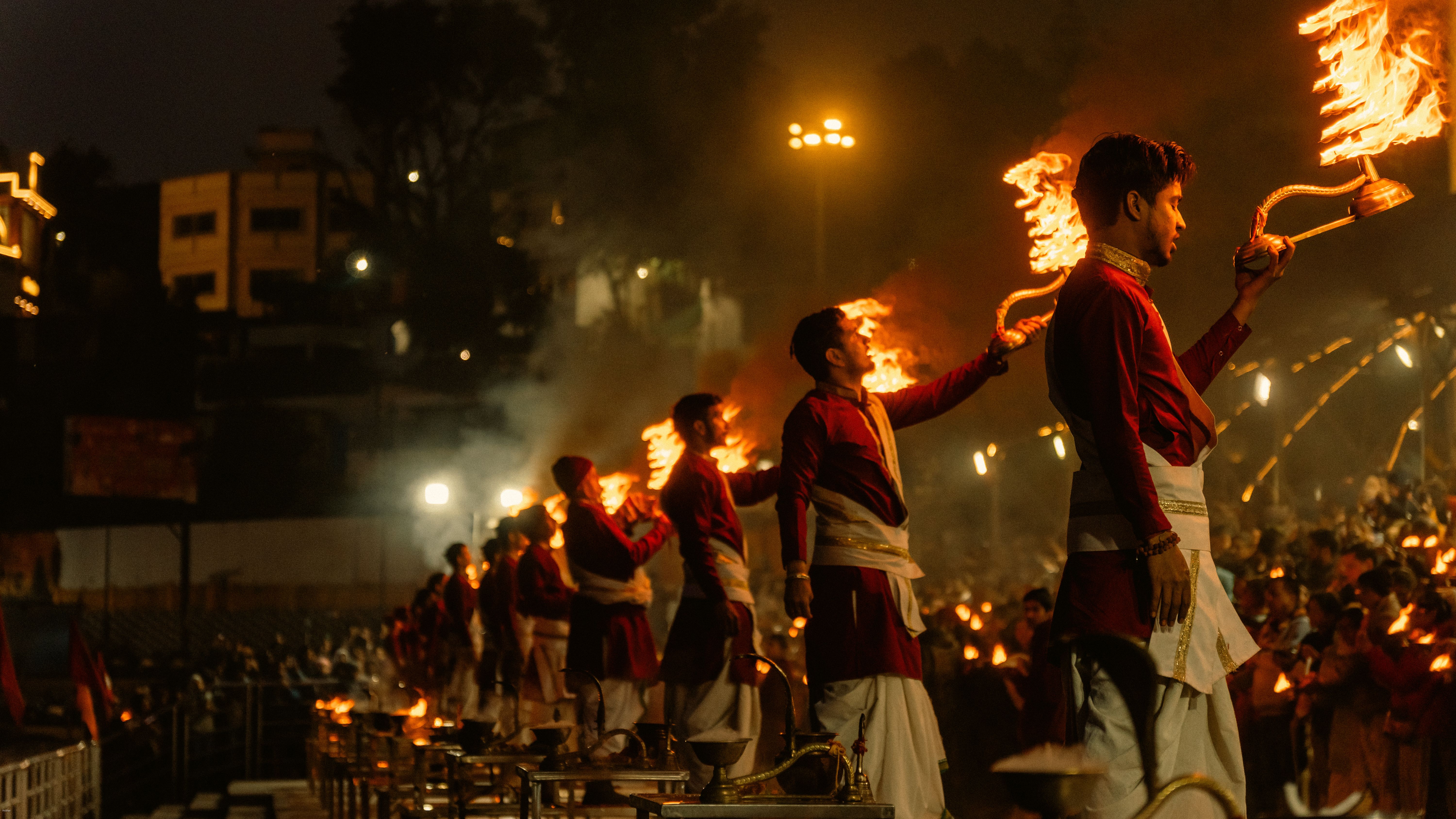Priests raising lamps during the evening aarti beside the Ganga